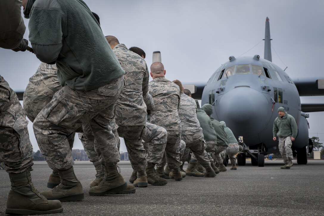 Members of the 374th Aircraft Maintenance Squadron pull a C-130H Hercules down the runway during the 374th Maintenance Group Wrenchbender Rodeo March 31, 2017, at Yokota Air Base, Japan. Teams from various maintenance squadrons competed against each other in nine events including: 4-man push-ups, vehicle push, blindfolded toolbox buildup, maintenance relay, tow bar obstacle course, leadership tool identification, chock hold, Self-Aid and Buddy Care relay and finished with a C-130 pull. (U.S. Air Force photo by Airman 1st Class Donald Hudson)