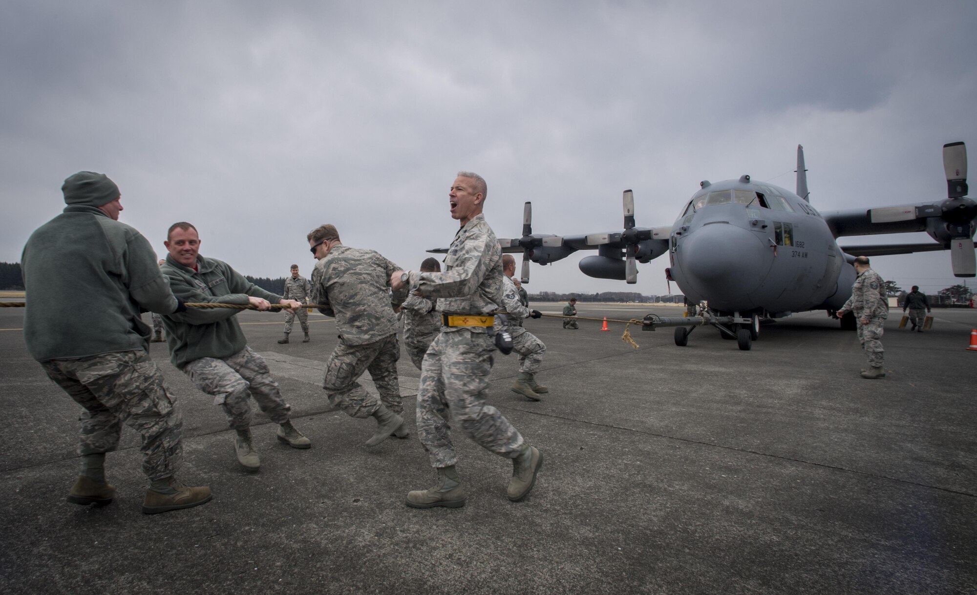 Lt. Col. Bernabe F. Whitfield, 374th Maintenance Group deputy commander, cheers a team on as they pull a C-130H Hercules down the runway during the 374th Maintenance Group Wrenchbender Rodeo March 31, 2017, at Yokota Air Base, Japan. Teams from various maintenance squadrons competed against each other in nine events including: 4-man push-ups, vehicle push, blindfolded toolbox buildup, maintenance relay, tow bar obstacle course, leadership tool identification, chock hold, Self-Aid and Buddy Care relay and finished with a C-130 pull. (U.S. Air Force photo by Airman 1st Class Donald Hudson)
