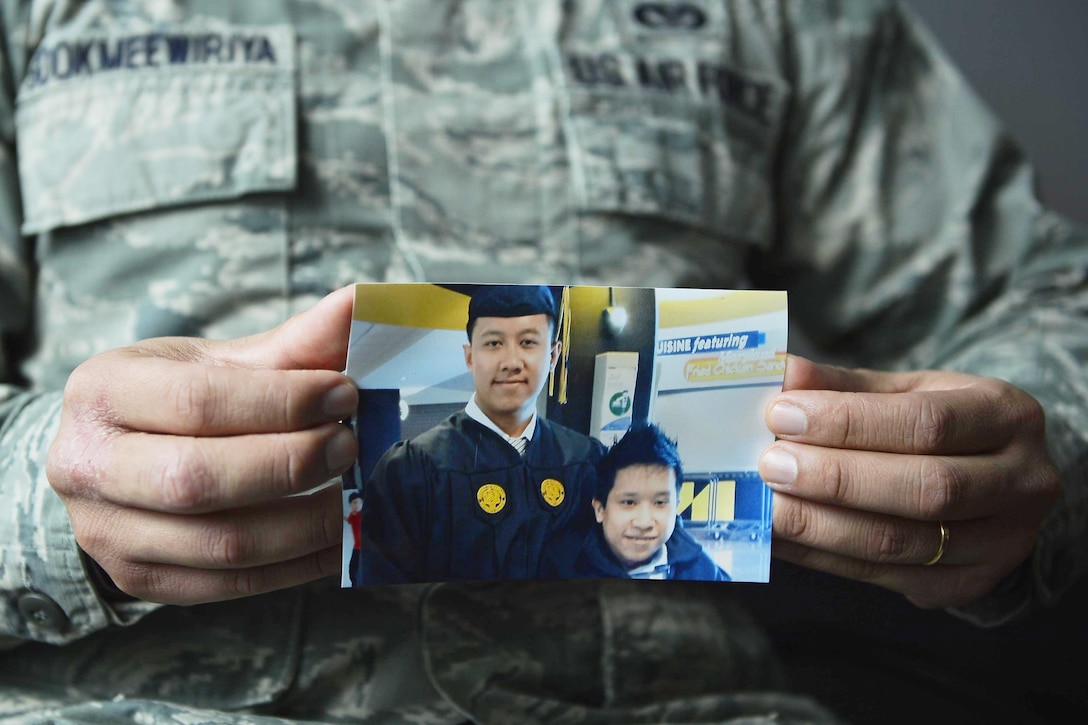 Air Force Staff Sgt. Srun Sookmeewiriya, 313th Expeditionary Operations Support Squadron noncommissioned officer in charge of reports, holds a picture of himself with his younger brother, Thana, at Ramstein Air Base, Germany, Feb. 16, 2017. Sookmeewiriya, who attempted to commit suicide twice, said he draws inspiration from his brother to remain resilient and encourages airmen to open up about their struggles. Air Force photo by Airman 1st Class Joshua Magbanua