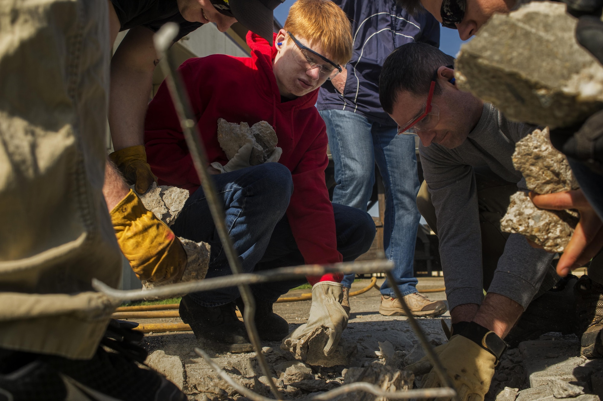 Scout Troop 165 works on picking up pieces of concrete during a community service project with Ka'eo Swartzmiller, Eagle Scout candidate, on Spangdahlem Air Base, Germany, March 25, 2016. Swartzmiller Eagle Scout project consists of widening the sidewalk, refurbishing the chapel gazebo and adding a concrete pad for the nativity scene. (U.S. Air Force photo by Staff Sgt. Jonathan Snyder)