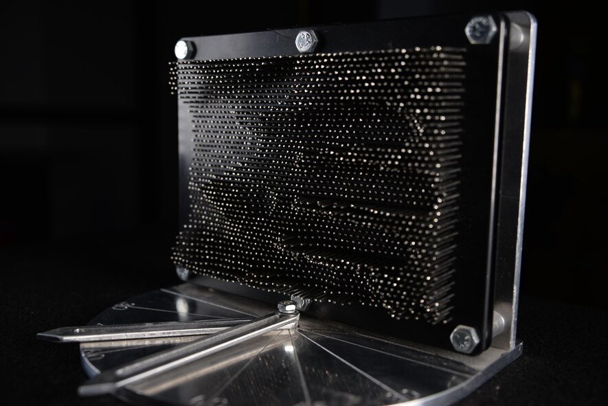 A prototype of the Actuated Pin Antenna Reflector is displayed. Capt. Daniel Stambovsky, a physicist assigned to the 32nd Intelligence Squadron at Fort Meade, Maryland, designed the prototype during his previous assignment at the Air Force Research Laboratory in Rome, New York. (U.S. Air Force photo/Staff Sgt. Alexandre Montes)