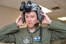 U.S. Air Force Reserve Lt. Col. Dan Collister, evaluator pilot, 327th Airlift Squadron, removes his helmet after focusing the pair of night vision goggles in preparation for a session in the C-130J simulator April 1, 2017, at Little Rock Air Force Base, Ark. Before flying operations, aircrews must pre-focus their NVG objective lenses at optical infinity. (U.S. Air Force photo by Master Sgt. Jeff Walston/Released)