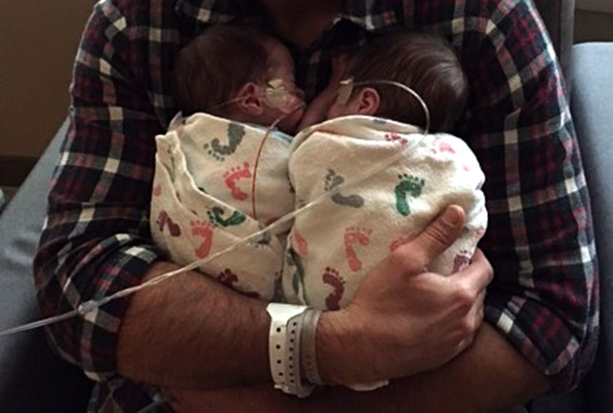 COLORADO SPRINGS, Colo. – John Aagaard, spouse of Staff Sgt. Susan Edwards-Aagaard, 21st Operations Support Squadron intelligence analyst, holds his newborn twins in Colorado Springs, Colo., Oct. 4, 2015. The twins were born seven weeks early with many health issues, but get stronger as each day passes. (Courtesy photo)