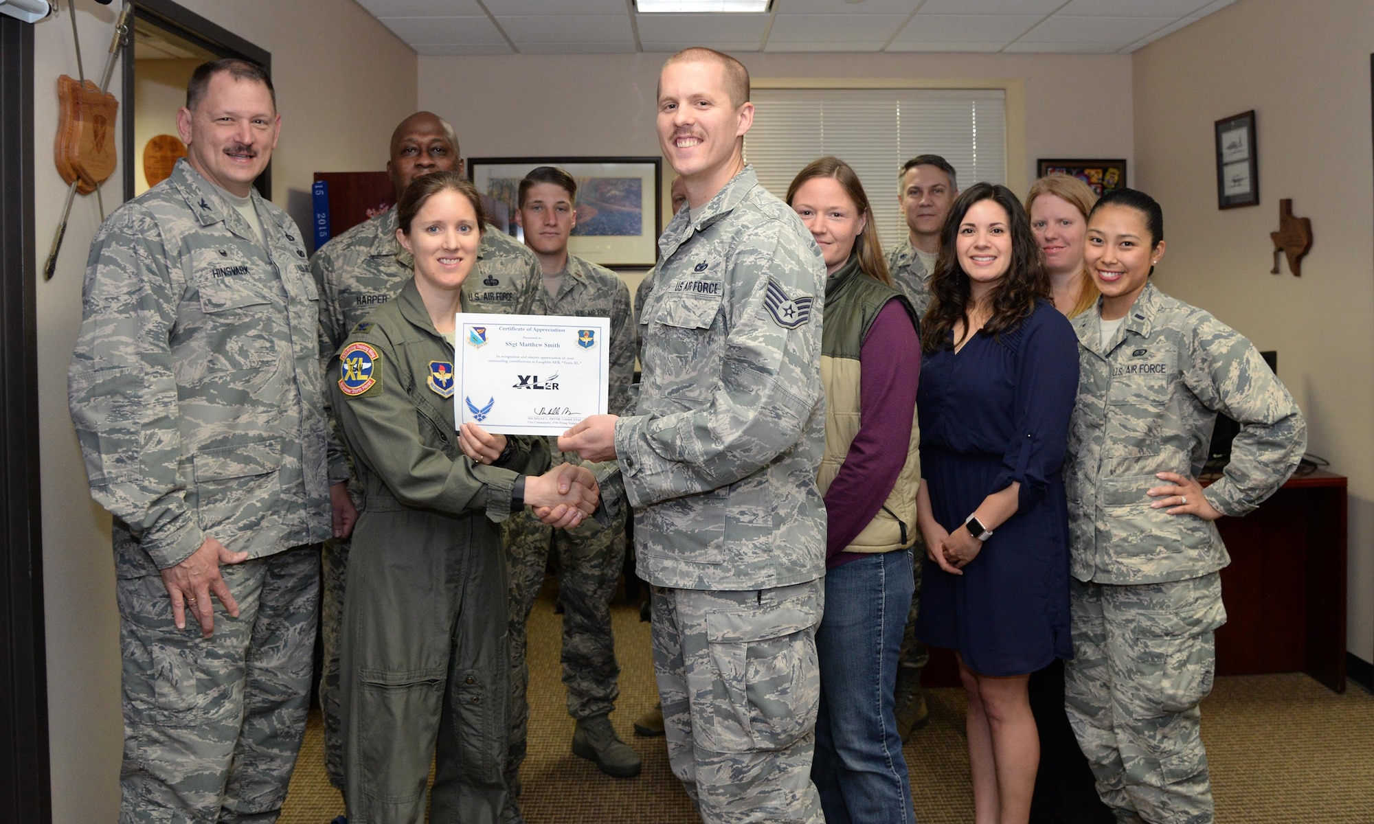 Staff Sgt. Matthew Smith, 47th Mission Support Group unit deployment manager (center), accepts the “XLer of the Week” award from Col. Michelle Pryor, 47th Flying Training Wing vice commander (left), and Chief Master Sgt. George Richey, 47th FTW command chief (right), on Laughlin Air Force Base, Texas, March 29, 2017. The XLer is a weekly award chosen by wing leadership and is presented to those who consistently make outstanding contributions to their unit and Laughlin. (U.S. Air Force photo/Airman 1st Class Daniel Hambor)