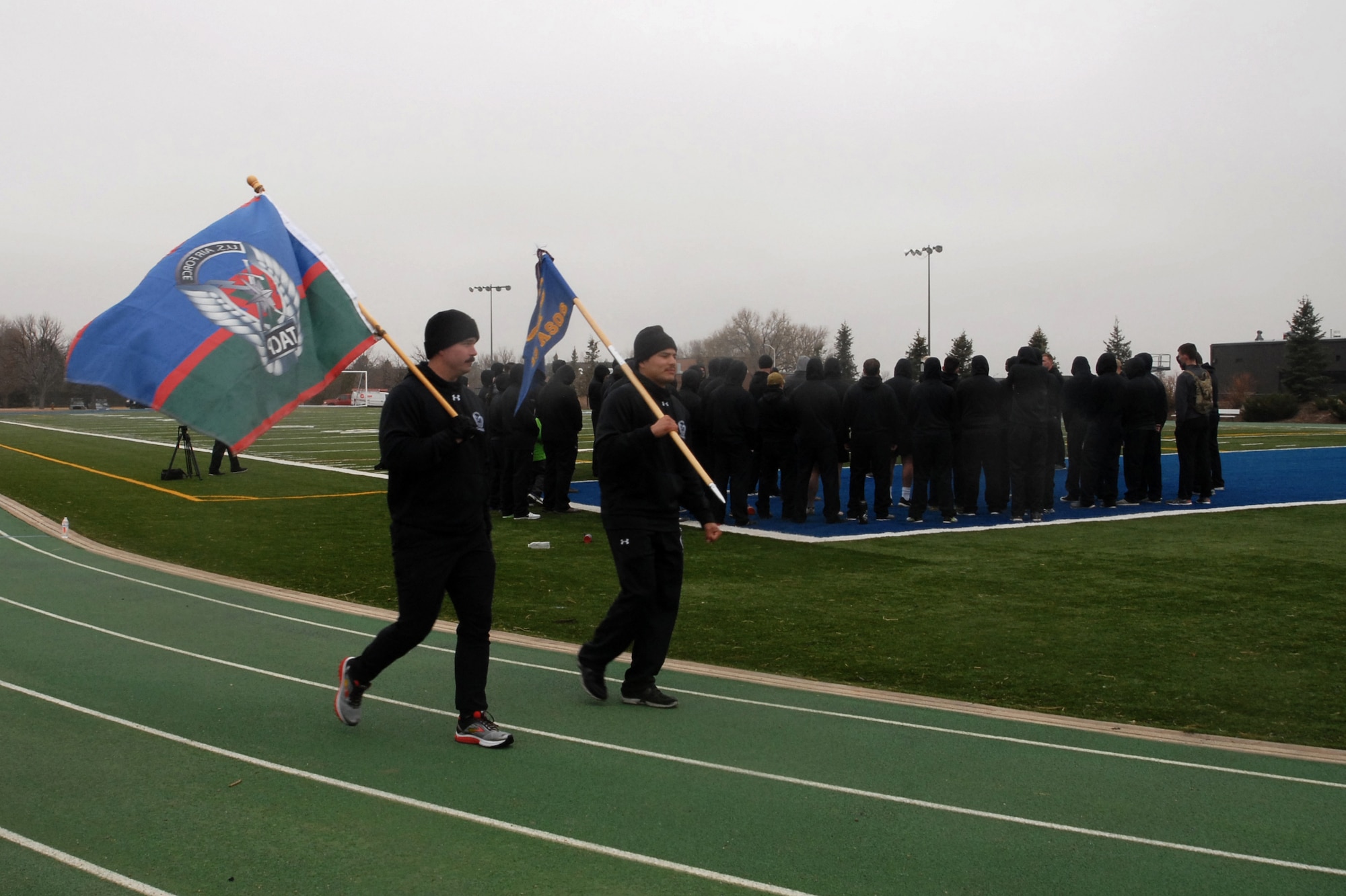 PETERSON AIR FORCE BASE, Colo. – Members of the 13th Air Support Operations Squadron continue to move the Tactical Air Control Party flag and their unit guide-on around the track during the 24-Hour Challenge run while the rest of their unit gather to remember their fallen brethren at Peterson Air Force Base, Colo., March 31, 2017. The run is done annually around the world to honor fallen Tactical Air Control Party Airmen and raise money to help members of the TACP community and their families. (U.S. Air Force photo by Shellie-Anne Espinosa)