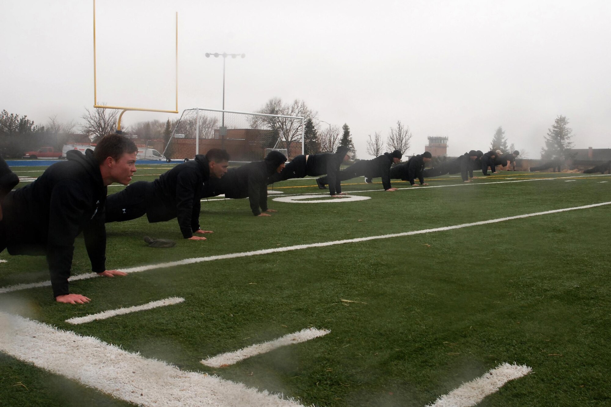 PETERSON AIR FORCE BASE, Colo. – Members of the 13th Air Support Operations Squadron complete pushups for each fallen Tactical Air Control Party Airmen as the rain begins to fall at Peterson Air Force Base, Colo., March 31, 2017. They formed up to do pushups after completing the 24-Hour Challenge run done around the world to honor fallen TACP Airmen and raise money to help members of the TACP community and their families. (U.S. Air Force photo by Shellie-Anne Espinosa)