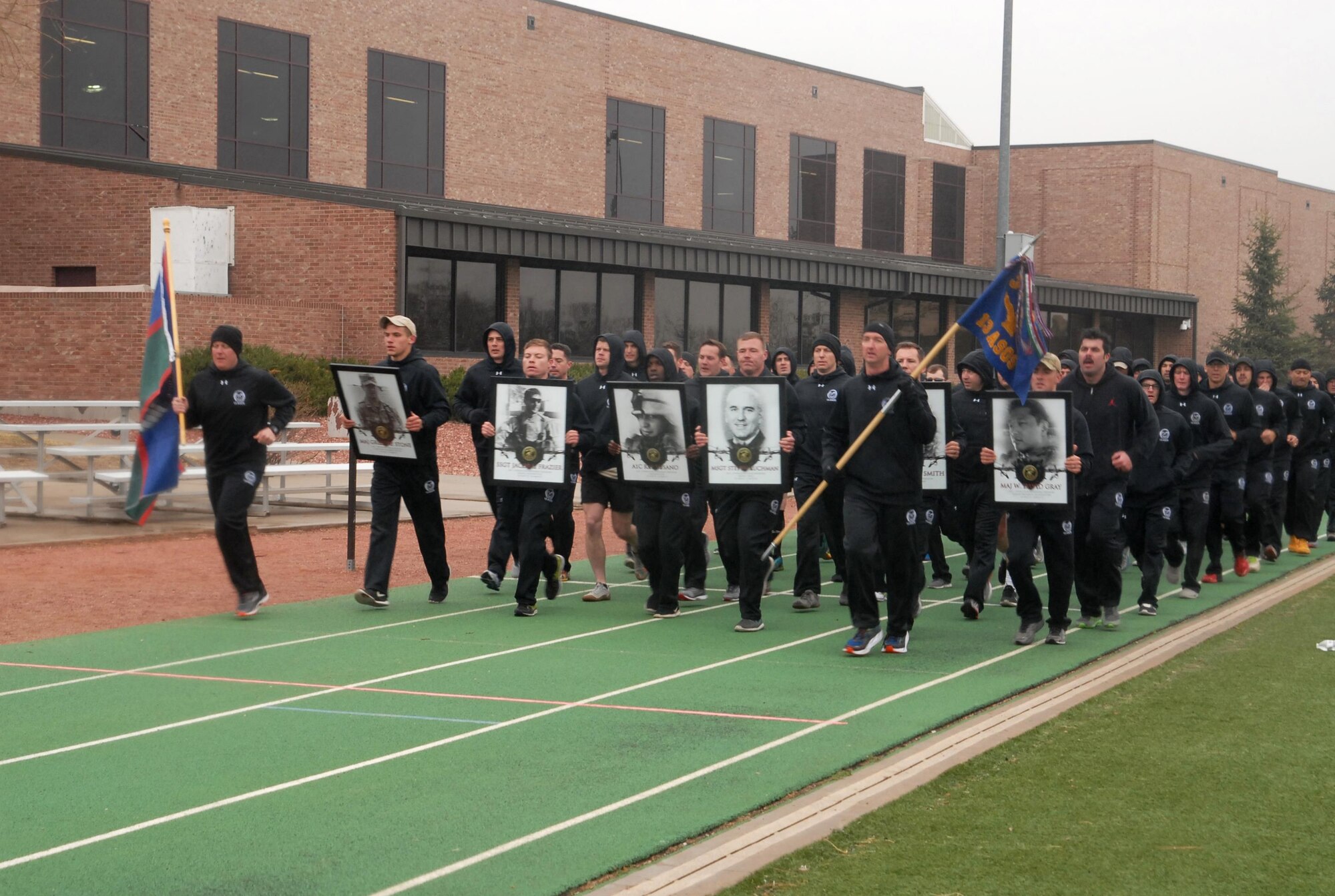 PETERSON AIR FORCE BASE, Colo. — Members of the 13th Air Support Operations Squadron hold pictures of fallen Tactical Air Control Party Airmen while running in formation as they complete the last mile of the sixth annual 24-Hour Challenge run at Peterson Air Force Base, Colo., March 31, 2017. The run is done around the world to honor fallen Tactical Air Control Party Airmen and raise money to help members of the TACP community and their families. (U.S. Air Force photo by Shellie-Anne Espinosa)