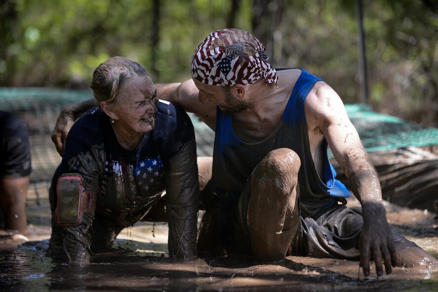 A runner helps another participant out of a mud pit during the 2017 Defenders of Liberty Mud Run at Barksdale Air Force Base, La., April 1. The event hosted both military and local community members of various age groups with waves of both competitive and noncompetitive runners. (U.S. Air Force photo/Senior Airman Mozer O. Da Cunha)