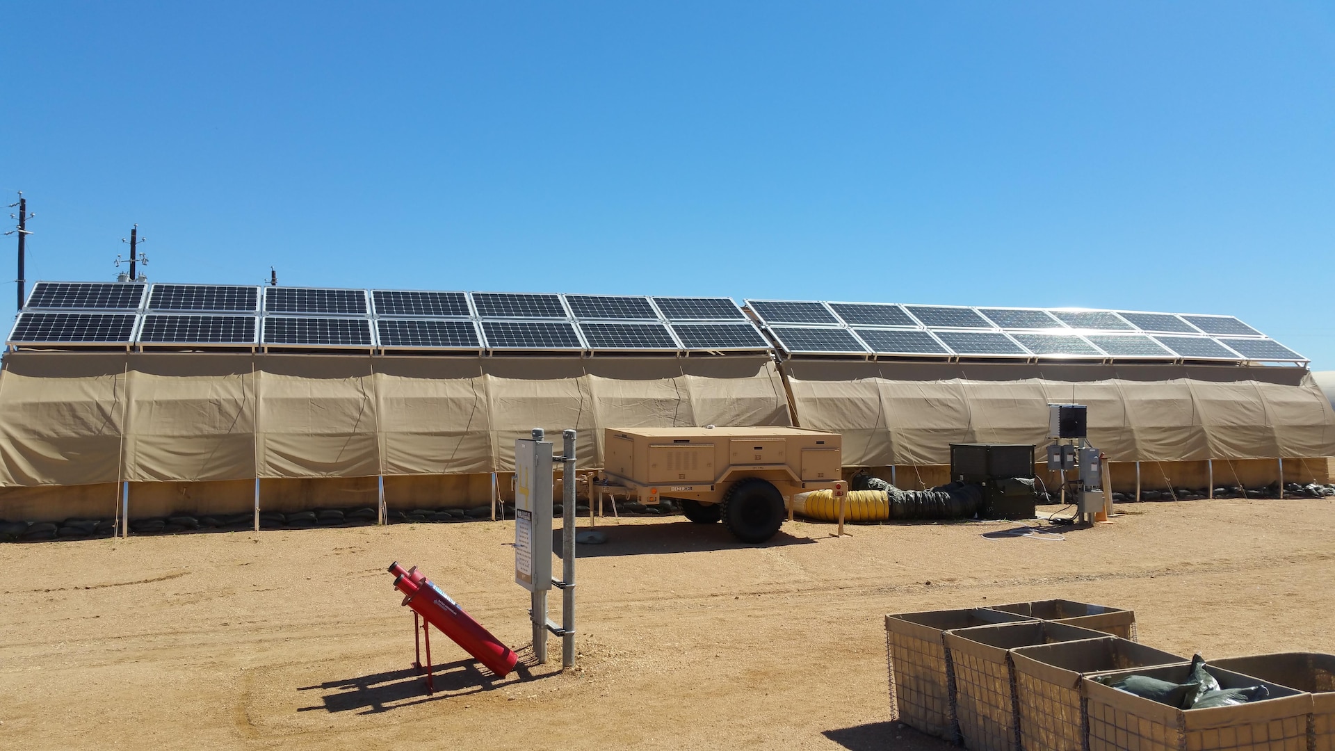 Part of AFRL's Forward Operating Base of the Future demonstration is one complete expeditionary microgrid system at Basic Expeditionary Airmen Skills Training (BEAST), Lackland AFB, San Antonio, Texas. Monocrystalline silicon solar panels are placed on top of each tent for energy production. A trailer (center) holds the hardware, software and lithium ion batteries that form the smart grid and provide energy backup should the grid fail. The project evaluates energy reduction technologies such as shelter insulation and efficient HVACs. (U.S. Air Force photo/Jason Goins)