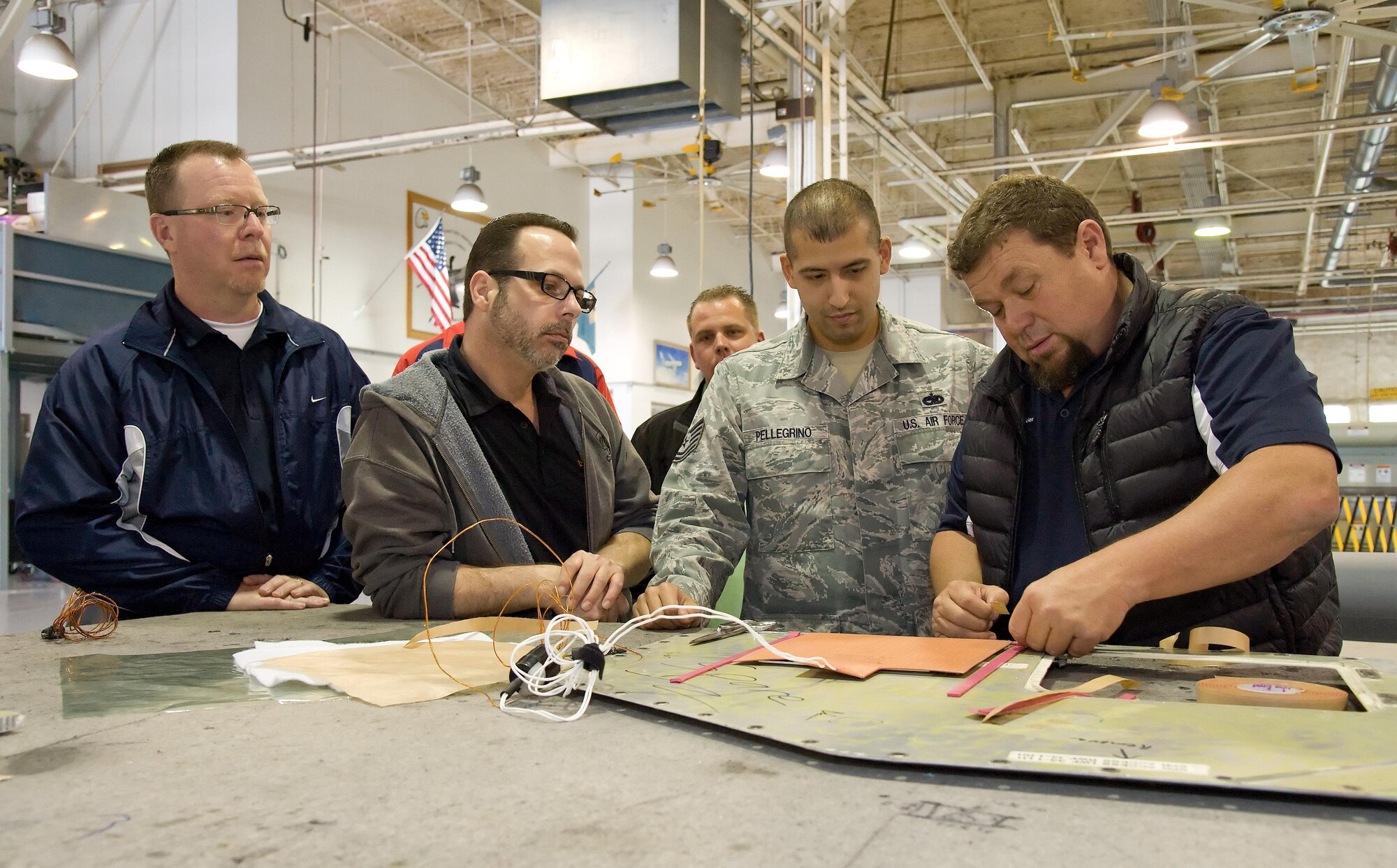 Honorary commander Mike Caloway, 9th Airlift Squadron, and John Yoho, Honorary Commander alumni, watch Rob Meding, 436th Logistics Readiness Squadron honorary commander, prepare an aircraft panel for hot bonding March 29, 2017, on Dover Air Force Base, Del. Tech. Sgt. Kenny Pellegrino, 436th Maintenance Squadron sheet metal craftsman, explained to Meding and the others about each step of the hot bonding process. (U.S. Air Force photo by Roland Balik)