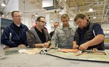 Honorary commander Mike Caloway, 9th Airlift Squadron, and John Yoho, Honorary Commander alumni, watch Rob Meding, 436th Logistics Readiness Squadron honorary commander, prepare an aircraft panel for hot bonding March 29, 2017, on Dover Air Force Base, Del. Tech. Sgt. Kenny Pellegrino, 436th Maintenance Squadron sheet metal craftsman, explained to Meding and the others about each step of the hot bonding process. (U.S. Air Force photo by Roland Balik)