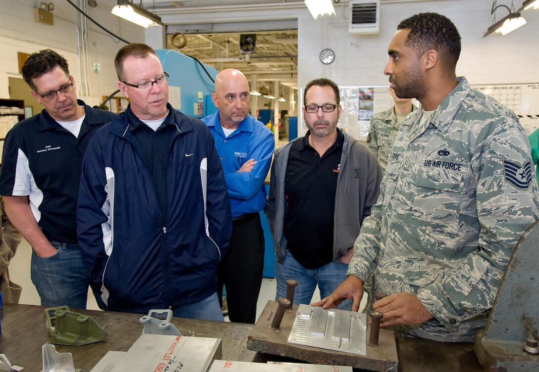 Honorary commanders Todd Ewald, 436th Aircraft Maintenance Squadron; Mike Caloway, 9th Airlift Squadron; Tom Banez, Air Force Mortuary Affairs Operations; and John Yoho, Honorary Commander alumni, listen to Tech. Sgt. Shawn Walters, 436th Maintenance Squadron metals technology craftsman, elaborate on a current project March 29, 2017, on Dover Air Force Base, Del. Walters explained the process of using computer aided drafting technology for machining parts out of aluminum. (U.S. Air Force photo by Roland Balik)