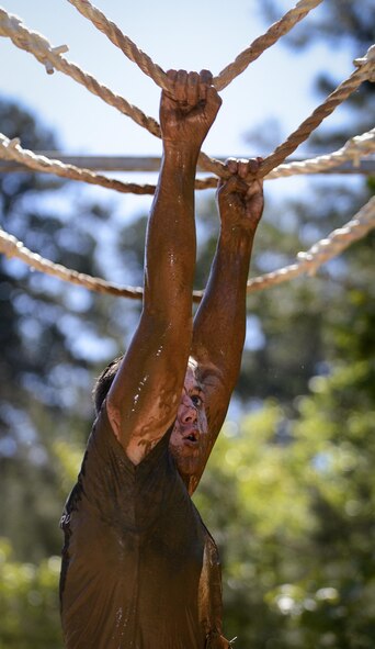 Staff Sgt. Tyler Berthelot, 2nd Aircraft Maintenance Squadron flight control systems journeyman, crosses an obstacle during the 2017 Defenders of Liberty Mud Run at Barksdale Air Force Base, La., April 1. The race offered competitive and noncompetitive waves throughout the day. (U.S. Air Force photo/Senior Mozer O. Da Cunha)