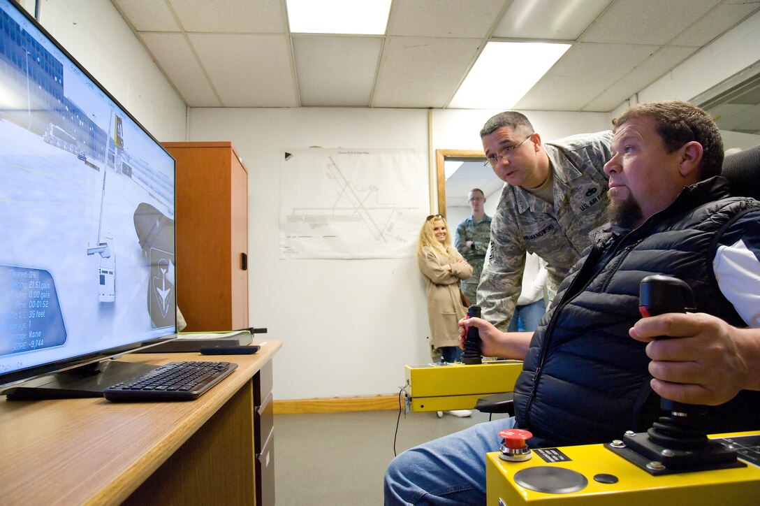 Tech. Sgt. Donald Hilmanowski, 736th Aircraft Maintenance Squadron vehicle control NCO in charge, instructs Rob Meding, 436th Logistics Readiness Squadron honorary commander, on how to de-ice a C-17 Globemaster III using the Global GS deicing simulator March 29, 2017, on Dover Air Force Base, Del. The simulator allows aircraft maintainers to practice deicing procedures on 16 different types of aircraft using forced air and/or glycol to remove snow and ice. (U.S. Air Force photo by Roland Balik)