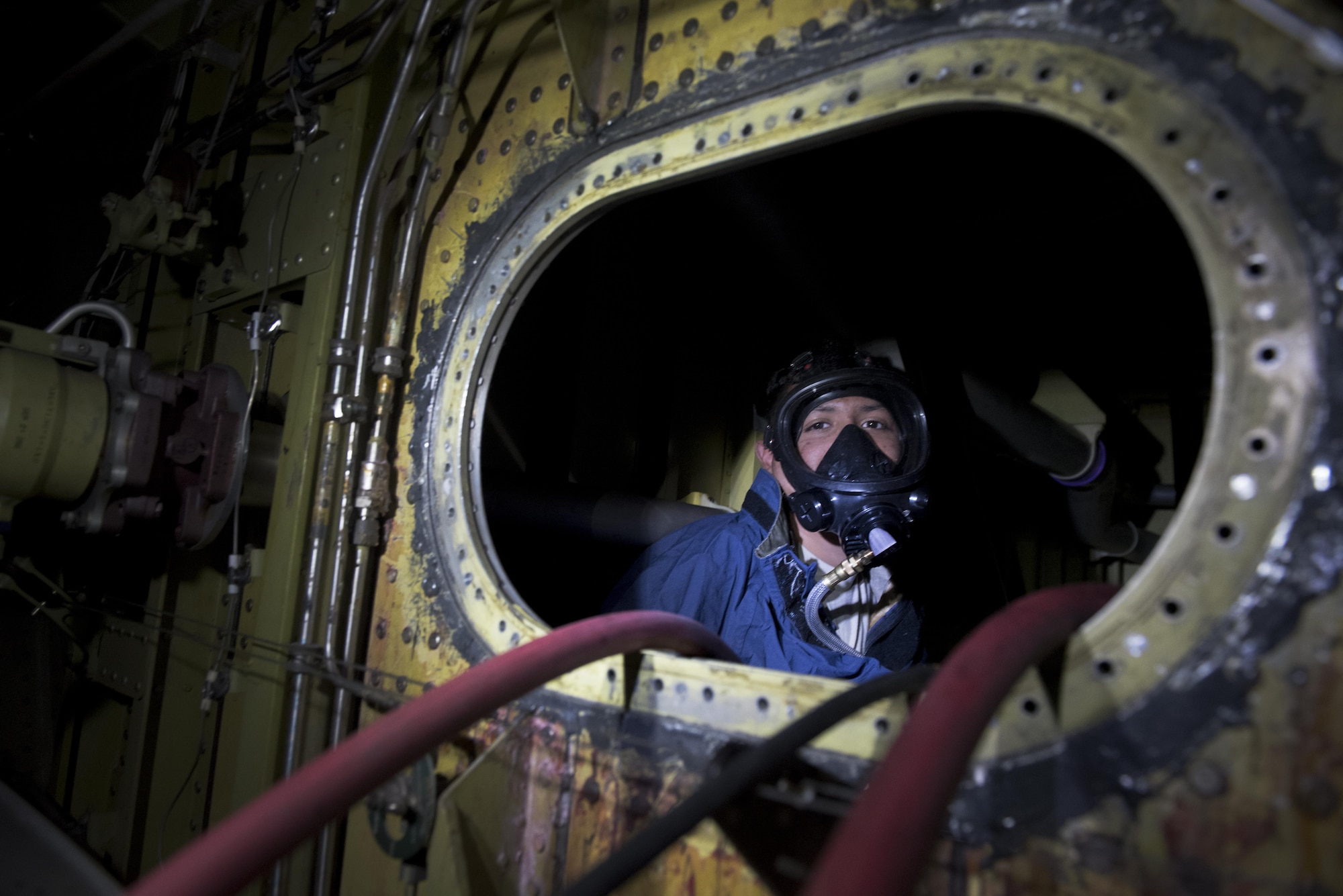 Airman 1st Class Diego Vigil-Alas with the 305th Maintenance Squadron looks out from the fuel tank of a KC-10 Extender at Joint Base McGuire-Dix-Lakehurst, New Jersey, April 5, 2017. The fuel cells of the aircraft are emptied before maintenance can be performed.