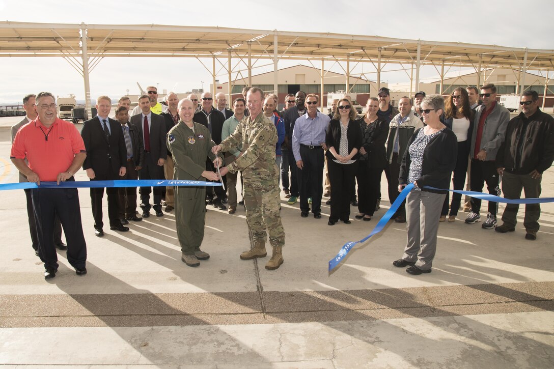 With scissors in hand, Brig. Gen. Carl Schaefer, 412th Test Wing commander (left, and Army Col. Kirk Gibbs, U.S. Army Corps of Engineers Los Angeles District commander, prepare to cut the ceremonial ribbon signifying the official opening of the new 411th Flight Test Squadron facility March 22. The squadron is responsible for the developmental testing of the F-22 Raptor and its systems. (U.S. Air Force photo by Christian Turner