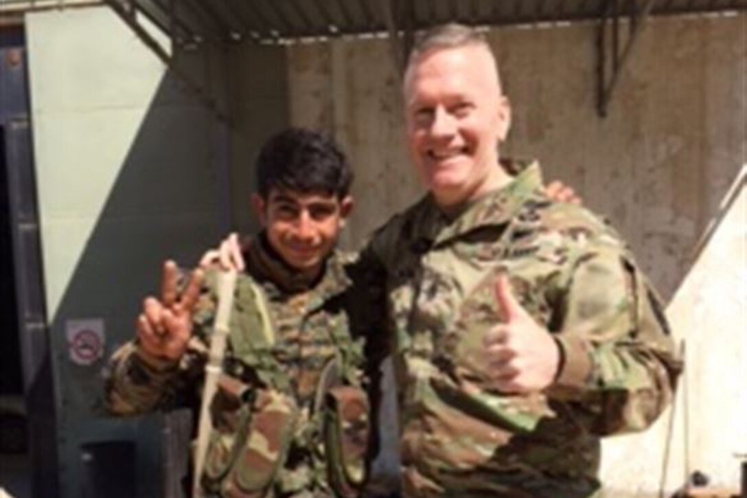 Army Command Sgt. Maj. John Wayne Troxell, the senior enlisted advisor to the chairman of the Joint Chiefs of Staff, poses with a young Syrian Democratic Forces soldier near Kobani, Syria, April 4, 2017. Courtesy photo