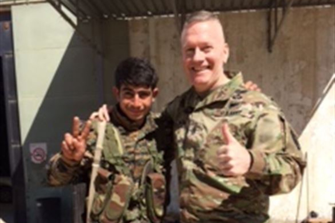 Army Command Sgt. Maj. John Wayne Troxell, the senior enlisted advisor to the chairman of the Joint Chiefs of Staff, poses with a young Syrian Democratic Forces soldier near Kobani, Syria, April 4, 2017. Courtesy photo