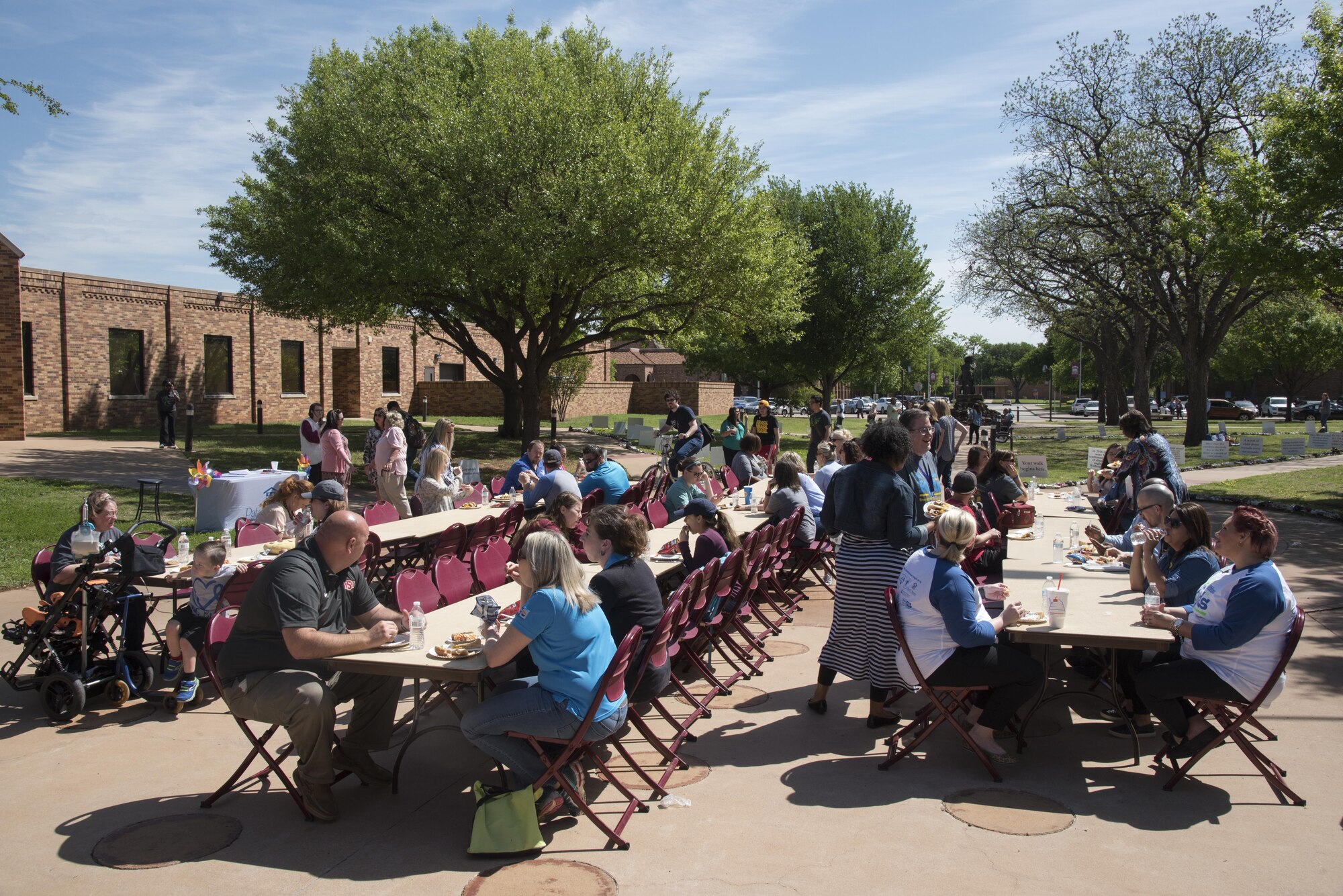 Community members gather at the annual Walk of Knowledge April 4, 2017, hosted by the Sheppard Family Advocacy group and the Wichita Falls Child Abuse Prevention Committee at Midwestern State University. In addition to enjoying refreshments, participants walked the sidewalk lined with educational signs and 585 pairs of children’s shoes representing each case of confirmed child abuse in Wichita County during 2016. (U.S. Air Force photo by 2nd Lt. Jacqueline Jastrzebski)