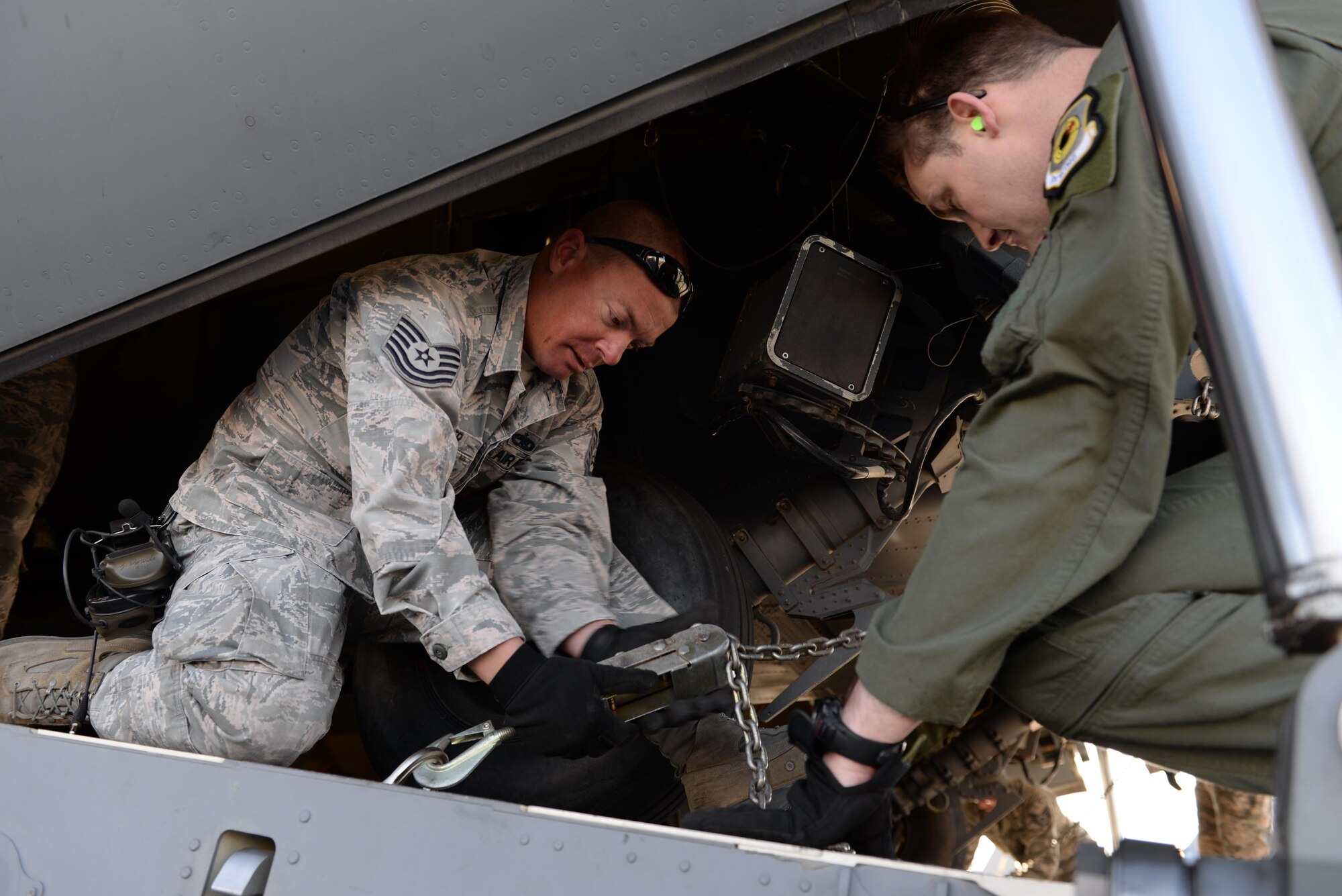 Airmen, 34th Weapons Squadron, tighten a cargo chain on a C-17 Globemaster III assigned to the 57th Weapons Squadron, McChord Air Force Base, Wash., at Nellis Air Force Base, Nev., March 28, 2017. The C-17 transported two HH-60 Pave Hawk helicopters for a training exercise. (U.S. Air Force photo by Airman 1st Class Andrew D. Sarver/ Released)