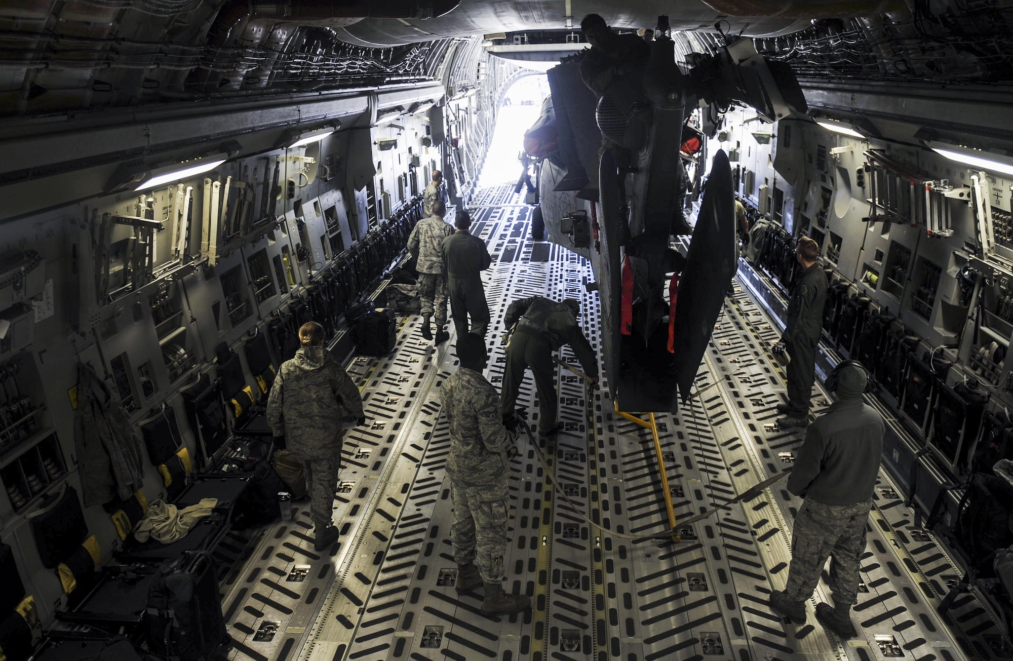 Airman from the 34th Weapons Squadron, secure a HH-60 Pave Hawk in the cargo area of a C-17 Globemaster III assigned to the 57th Weapons Squadron, McChord Air Force Base, Wash., March 28, 2017. The C-17 is capable of rapid strategic delivery of troops and all types of cargo to main operating bases or directly to forward bases in the deployment area. (U.S. Air Force photo by Airman 1st Class Kevin Tanenbaum/Released) 