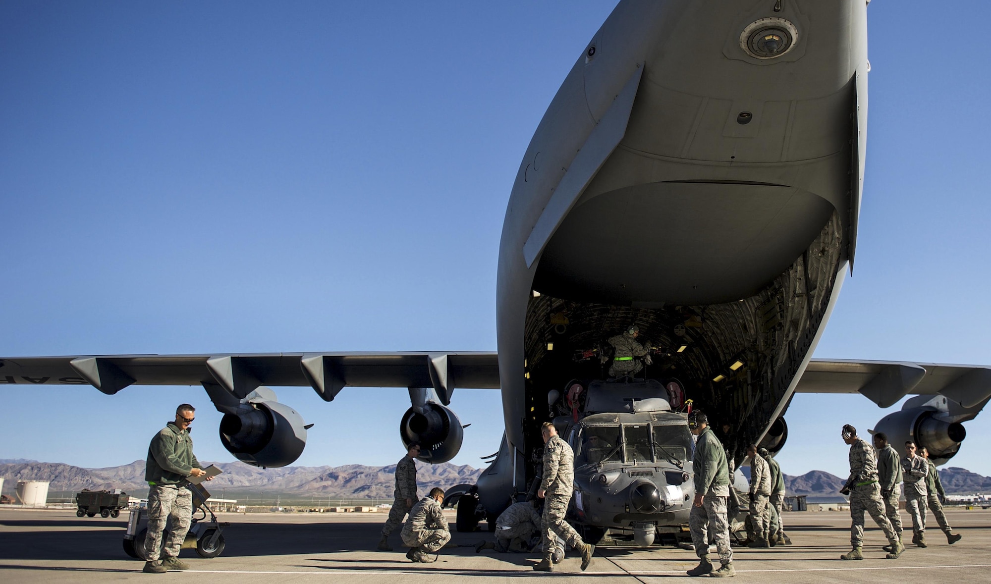 Airmen, 34th Weapons Squadron, finish loading the first of two HH-60 Pave Hawks into a C-17 Globemaster III assigned to the 57th Weapons Squadron, McChord Air Force Base, Wash., March 28, 2017. The Pave Hawk is a highly modified version of the Army Black Hawk helicopter, which features an upgraded communications and navigation suite. (U.S. Air Force photo by Airman 1st Class Kevin Tanenbaum/Released) 