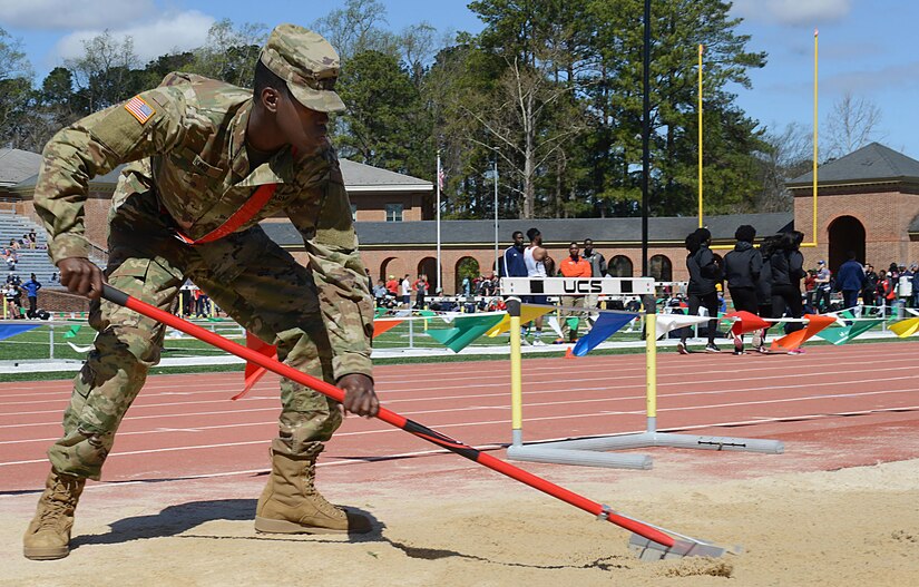 U.S. Army Pvt. Maurice King, Echo Company, 266th Quartermaster Battalion, 23rd Quartermaster Brigade advanced individual training student, rakes the long jump pit during a track and field meet at the College of William and Mary in Williamsburg, Va., April 1, 2017. During the event, Soldiers volunteered at the high jump, long jump, javelin and many other stations. (U.S. Air Force photo/Staff Sgt. Teresa J. Cleveland)
