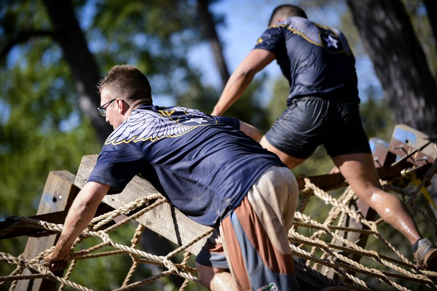 Barksdale Airmen climb an obstacle during the 2017 Defenders of Liberty Mud Run at Barksdale Air Force Base, La., April 1. The event included multiple waves to include a competitive squadron wave in which Airmen competed against each other for bragging rights. (U.S. Air Force photo/Senior Mozer O. Da Cunha)