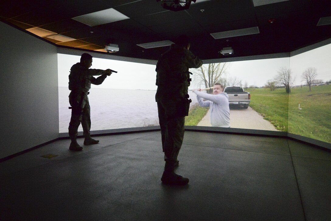 U.S. Air Force Staff Sgt. Ricardo Cuellar and Master Sgt. Alex Orino of the 129th Security Forces Squadron demonstrate the multitude use of the Multiple Interactive Learning Objectives (MILO) Range at Moffett Air National Guard Base, Calif., Feb. 15-2017.  The MILO Range, is a modular area designed to accommodate a multitude of training scenarios to law enforcement agencies. (U.S. Air National Guard photo by Senior Airman Zachiah Roberson/released)
