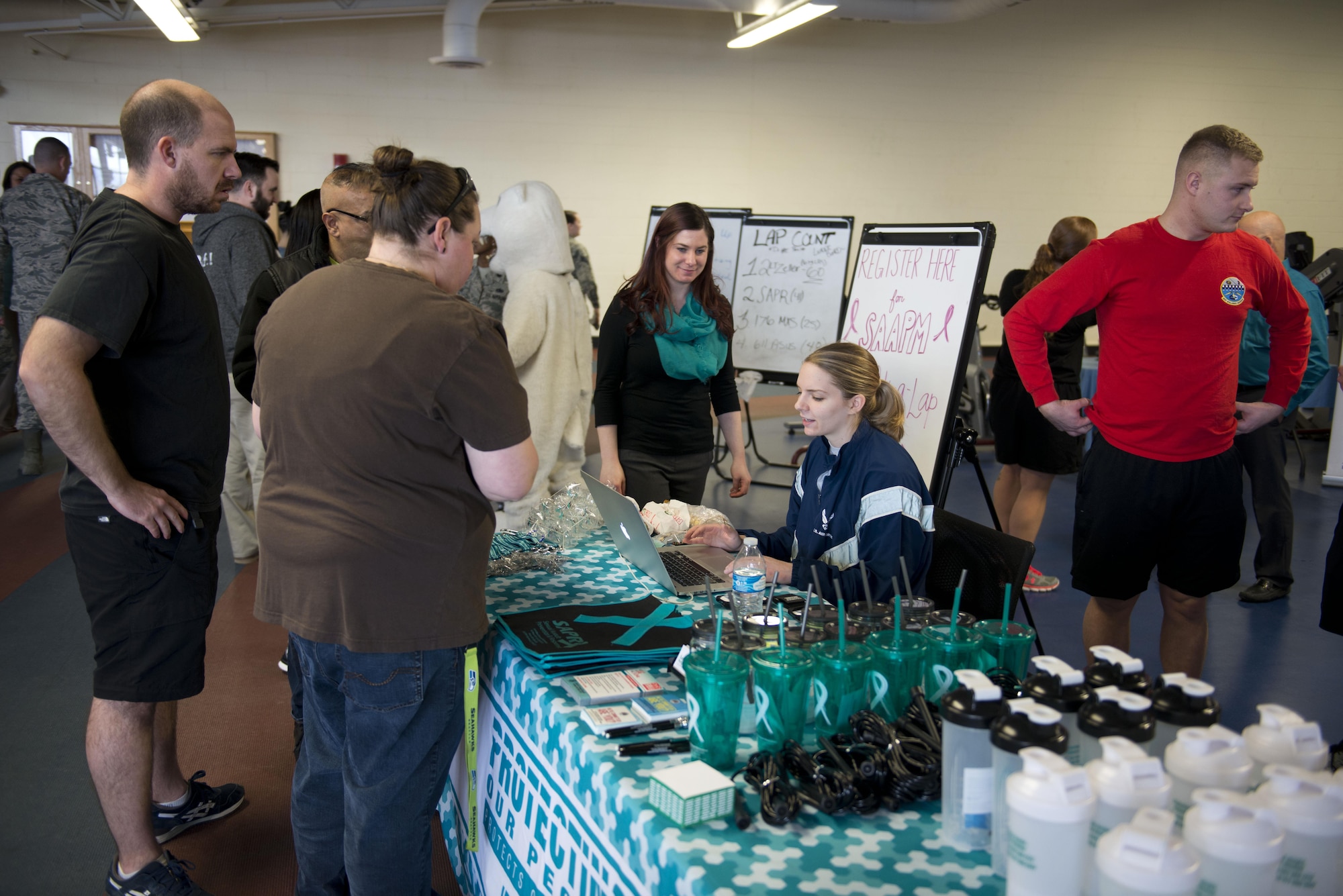 Airman 1st Class Lauren Cromie, a cryptologic linguist from the 381st Intel Squadron writes down participant's names and units before they begin their Walk-A-Lap event in the Elmendorf Fitness Center on Joint Base Elmendorf-Richardson, Alaska, April 5. The Sugarhill Ga. native volunteered to assist in the event with a goal of getting the base to walk 6,038 laps to honor each of the sexual assault survivors reported in the last fiscal year.