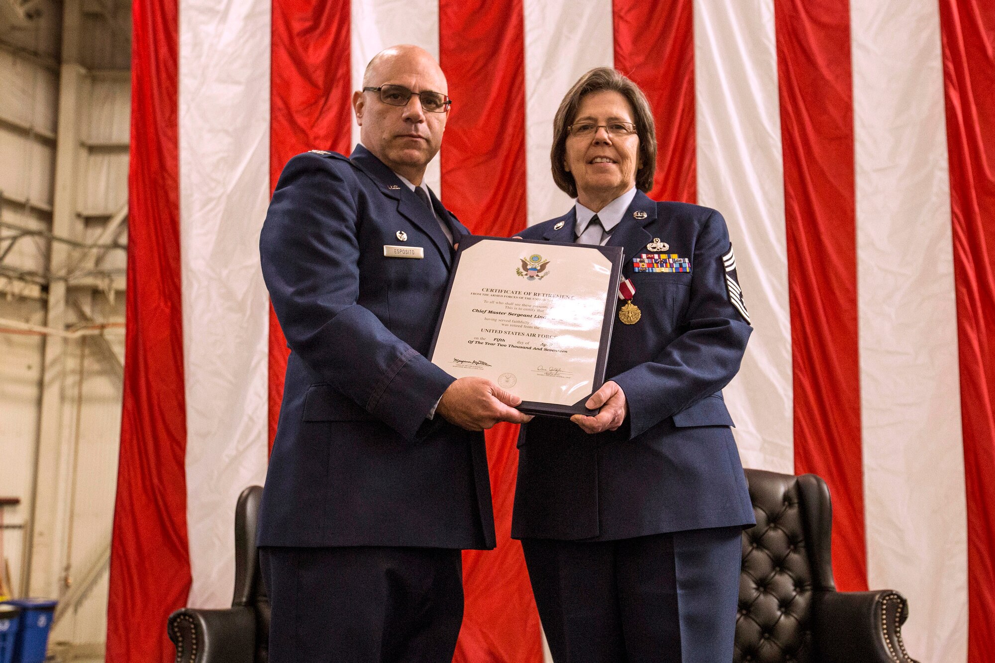Col. Anthony Esposito, left, the 514th Maintenance Group commander presents Chief Master Sgt. Linda L. Menser, the 514th Maintenance Group chief enlisted advisor and superintendent, her Retirement Certificate during the chief’s retirement ceremony at the 514th Air Mobility Wing, Joint Base McGuire-Dix-Lakehurst, N.J., April 2, 2017. As the Group superintendent, Menser was the Maintenance Group commander’s advisor on all matters concerning the health, morale, welfare, and effective management of 102 Air Reserve Technicians and 500 reserve enlisted members. Menser was also the first 514th Maintenance superintendent who was a woman. (U.S. Air Force photo by Master Sgt. Mark C. Olsen/Released)