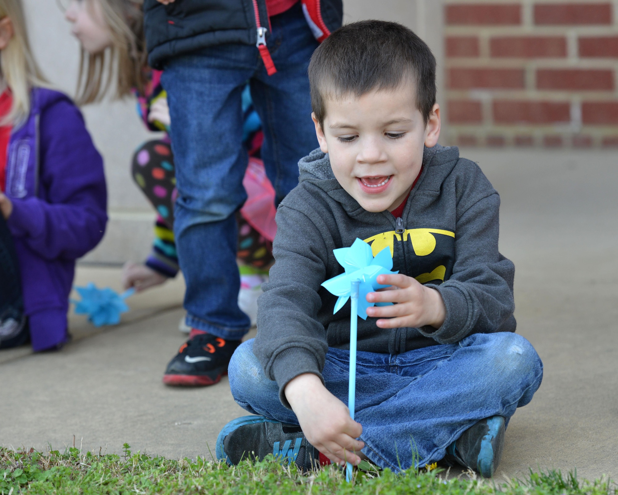 Carson Johnston, age 4, son of U.S. Air Force Staff Sgt. Nicole Johnston, 633rd Security Forces Squadron NCO in charge, plays with a pinwheel at the Russ Child Development Center annex at Joint Base Langley-Eustis, Va., April 3, 2017. Children from the CDC planted the pinwheels to raise awareness of child abuse. (U.S. Air Force photo/ Airman 1st Class Tristan Biese)