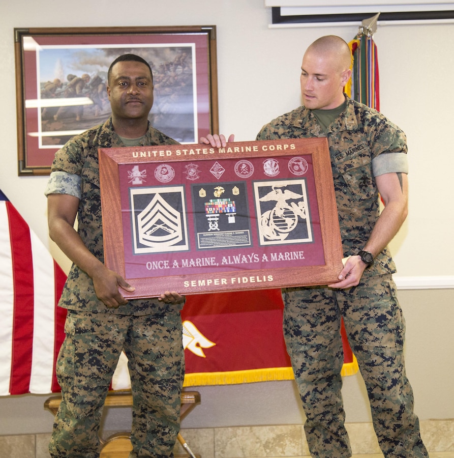 Gunnery Sgt. Eugene Skinner, outgoing base oerations chief, accepts a shadow box containing items representing his 23 years of service to the Corps from 1st Lieutenant Ryan J. Salisbury, deputy operations officer, MCLB Barstow, during Skinner's retirement ceremony March 31.