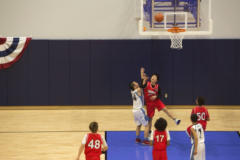 A Marine Corps Air Station Iwakuni basketball player attempts to block a Higashi Junior High School player’s shot during the Friendly Basketball Tournament at MCAS Iwakuni, Japan, March 25, 2017. The tournament was composed of six junior high school teams and bridged the gap of two cultures by helping children make new friends through a common interest. (U.S. Marine Corps photo by Pfc. Stephen Campbell)