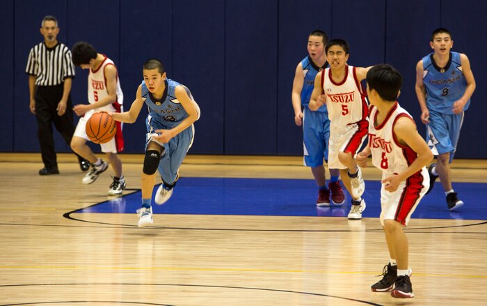 A player from the Higashi Junior High School basketball team dribbles the ball down the court during the Friendly Basketball Tournament at Marine Corps Air Station Iwakuni, Japan, March 25, 2017. The tournament was composed of six junior high school teams and bridged the gap of two cultures by helping children make new friends through a common interest. (U.S. Marine Corps photo by Pfc. Stephen Campbell)