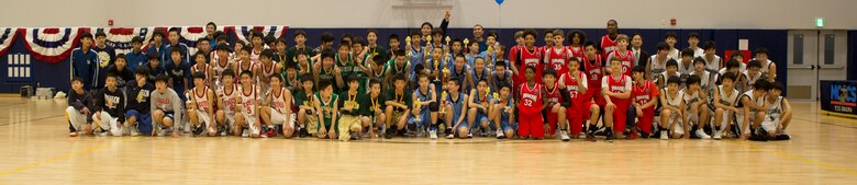 Participating teams pose together after the Friendly Basketball Tournament at Marine Corps Air Station Iwakuni, Japan, March 25, 2017. The tournament was composed of six junior high school teams  and bridged the gap of two cultures by helping children make new friends through a common interest. (U.S. Marine Corps photo by Pfc. Stephen Campbell)