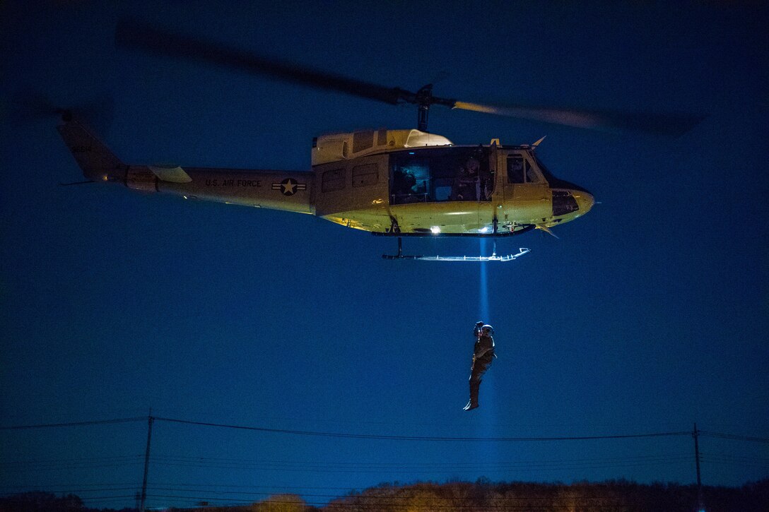 Capt. Lance M. Stafford, 36th Airlift Squadron pilot, is lifted into UH-N1 Iroquois during a 459th Airlift Squadron night hoist training exercise April 4, 2017, Tokyo, Japan. The aircrew performed hoist insertion and extraction from 25-35 feet above ground. (U.S. Air Force photo by Airman 1st Class Donald Hudson) 