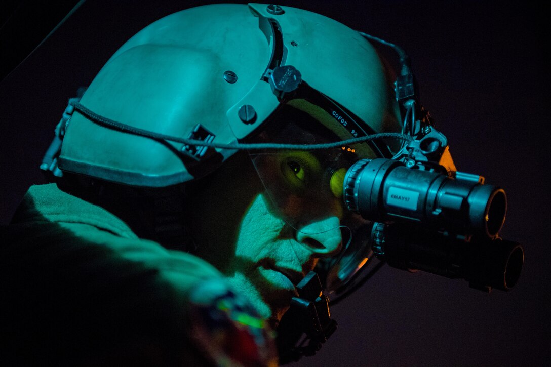 Staff Sgt. Nicholas A. Poe, 459th Airlift Squadron special mission’s aviator, looks out the window of a UH-N1 Iroquois through night vision goggles during a night hoist training exercise April 4, 2017, Tokyo, Japan. The aircrew trained with night vision goggles in the event a mission must be conducted at night in the future. (U.S. Air Force photo by Airman 1st Class Donald Hudson) 