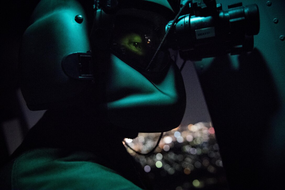 Staff Sgt. Nicholas A. Poe, 459th Airlift Squadron special mission’s aviator, looks out the window of a UH-N1 Iroquois through night vision goggles during a night hoist training exercise April 4, 2017, Tokyo, Japan. The aircrew trained with night vision goggles in the event a mission must be conducted at night in the future. (U.S. Air Force photo by Airman 1st Class Donald Hudson) 