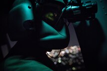 Staff Sgt. Nicholas A. Poe, 459th Airlift Squadron special mission’s aviator, looks out the window of a UH-N1 Iroquois through night vision goggles during a night hoist training exercise April 4, 2017, Tokyo, Japan. The aircrew trained with night vision goggles in the event a mission must be conducted at night in the future. (U.S. Air Force photo by Airman 1st Class Donald Hudson) 