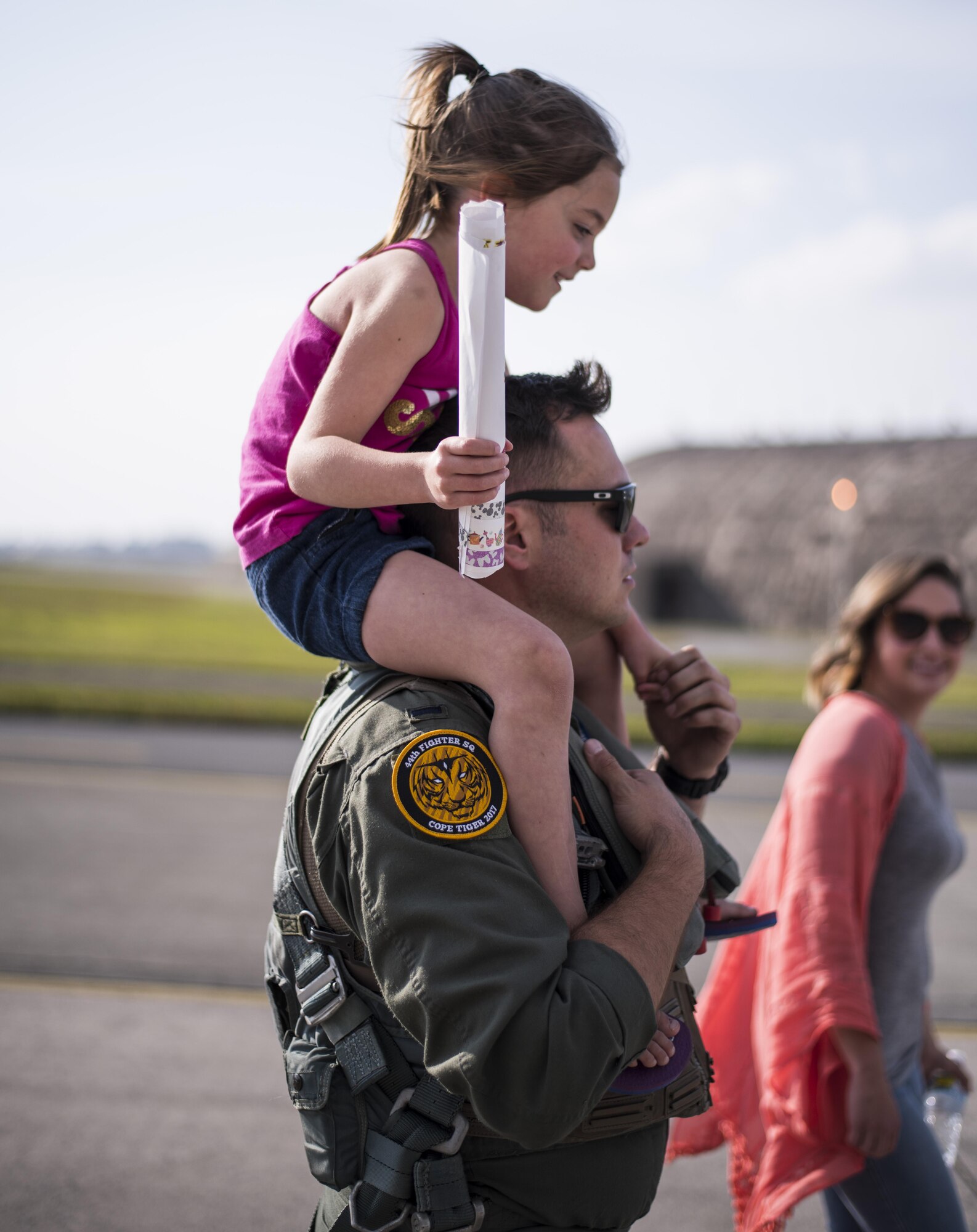 U.S. Air Force 1st Lt. Kyle Jones, 44th Fighter Squadron F-15 Eagle pilot, carries his daughter on his shoulders April 3, 2017, at Kadena Air Base, Japan. The 44th FS pilots recently returned from training at exercise Cope Tiger 2017. (U.S. Air Force photo by Senior Airman Omari Bernard/Released)