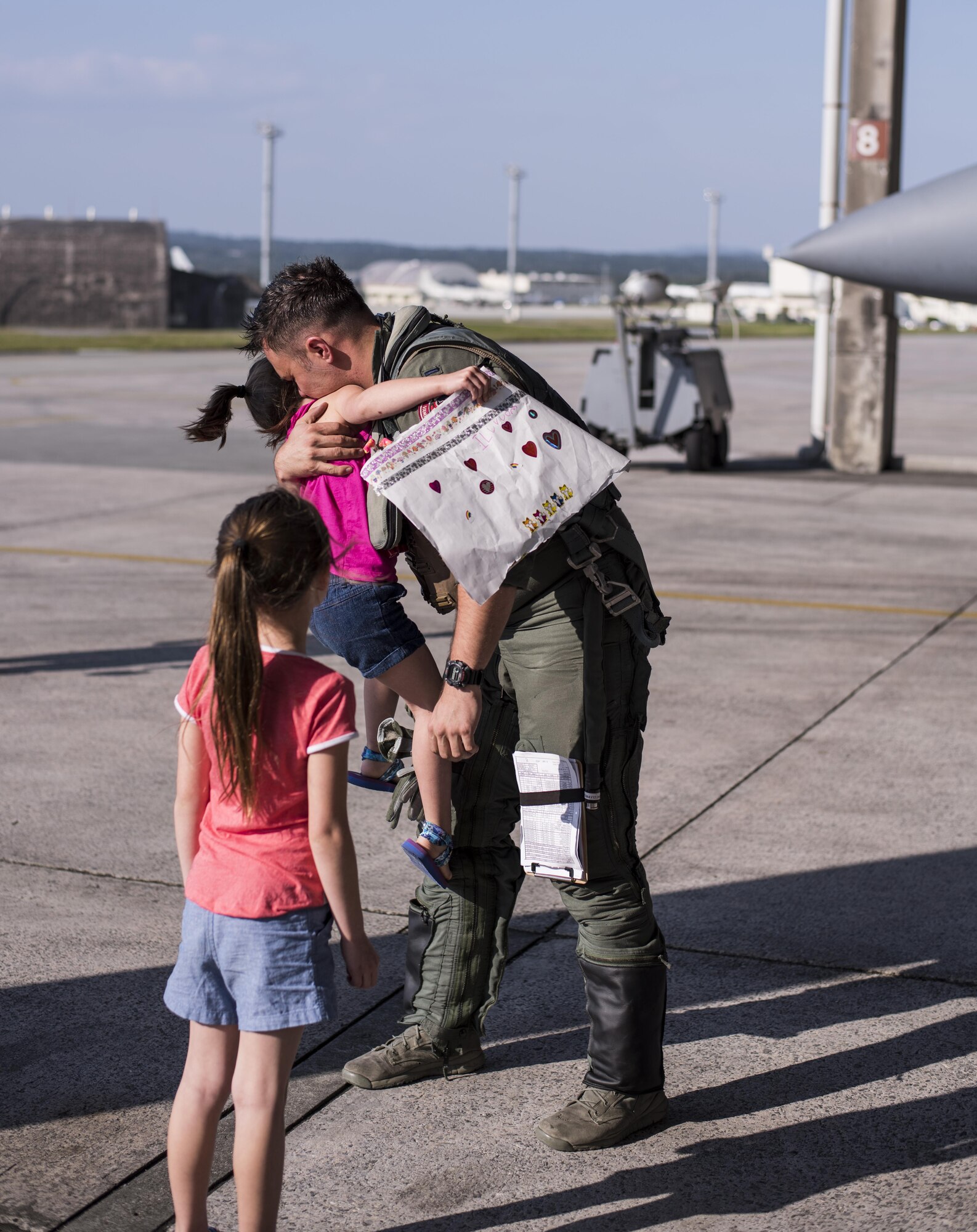 U.S. Air Force 1st Lt. Kyle Jones, 44th Fighter Squadron F-15 Eagle pilot, is welcomed home by his daughters on the flightline April 3, 2017, at Kadena Air Base, Japan. Pilots from the 44th FS returned to Kadena AB after participating in multinational exercise Cope Tiger 2017. (U.S. Air Force photo by Senior Airman Omari Bernard/Released)