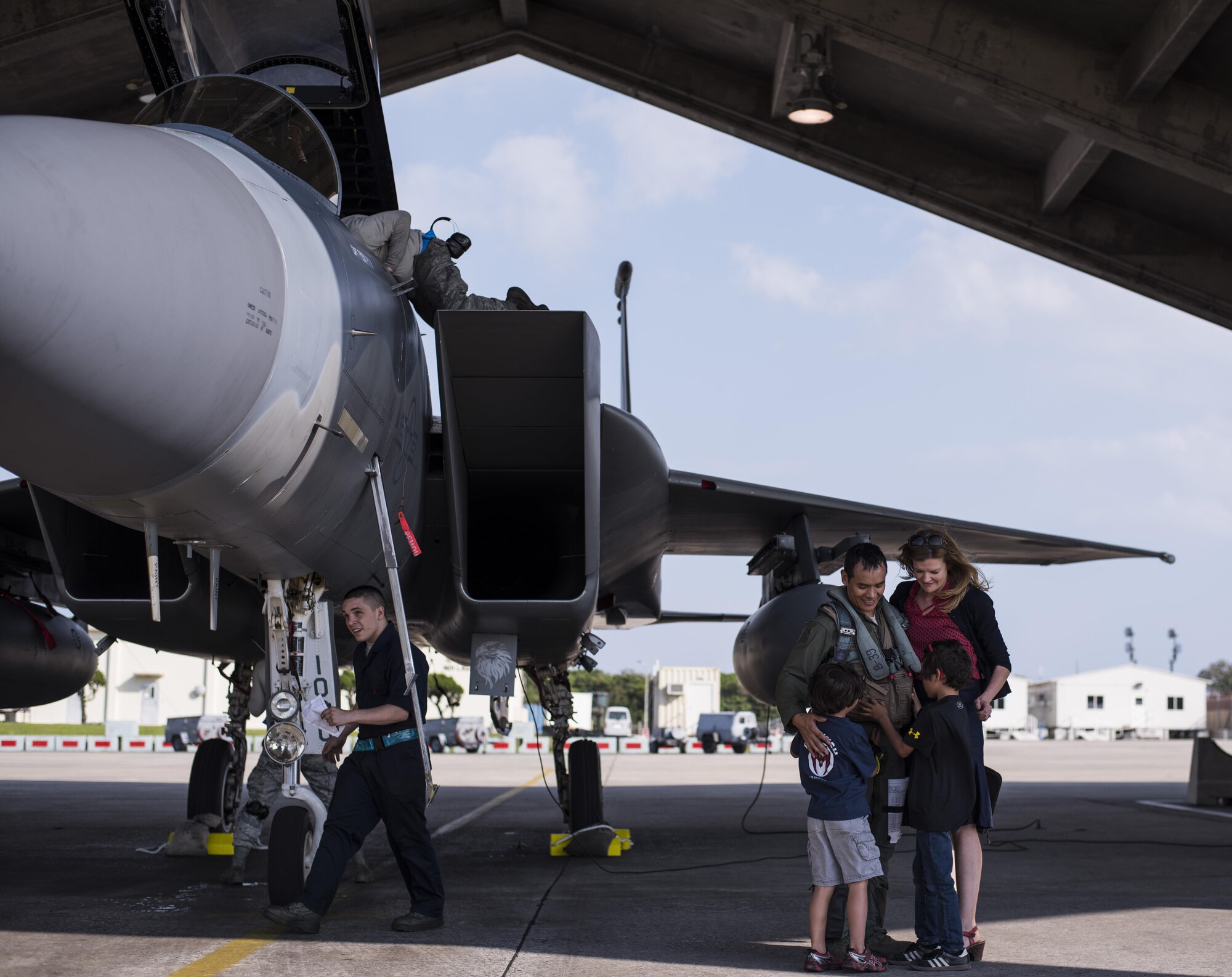 U.S. Air Force Lt. Col. Julius Romasanta, 44th Fighter Squadron F-15 Eagle pilot, embraces his family on the flightline April 3, 2017, at Kadena Air Base, Japan. Fighter pilots from the 44th FS returned from a two week annual exercise called Cope Tiger. Cope Tiger 2017 is a multilateral aerial exercise used to perfect wartime tactics and increase interoperability between the U.S. Air Force, Royal Thai Air Force and the Republic of Singapore Air Force. (U.S. Air Force photo by Senior Airman Omari Bernard/Released)