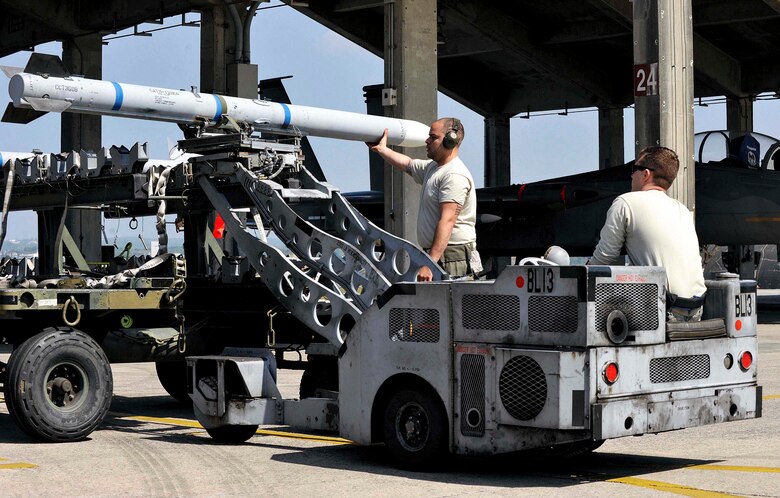 A U.S. Air Force weapons load crew team from the 44th Aircraft Maintenance Unit uses an MJ-1C lift truck to transport an AIM-120 advanced medium-range air-to-air missile to an F-15 Eagle fighter aircraft during a quarterly weapons load competition April 3, 2017, at Kadena Air Base, Japan. Weapons load competitions are conducted quarterly to keep Airmen sharp and recognize superior performers. (U.S. Air Force photo by Naoto Anazawa/Released)