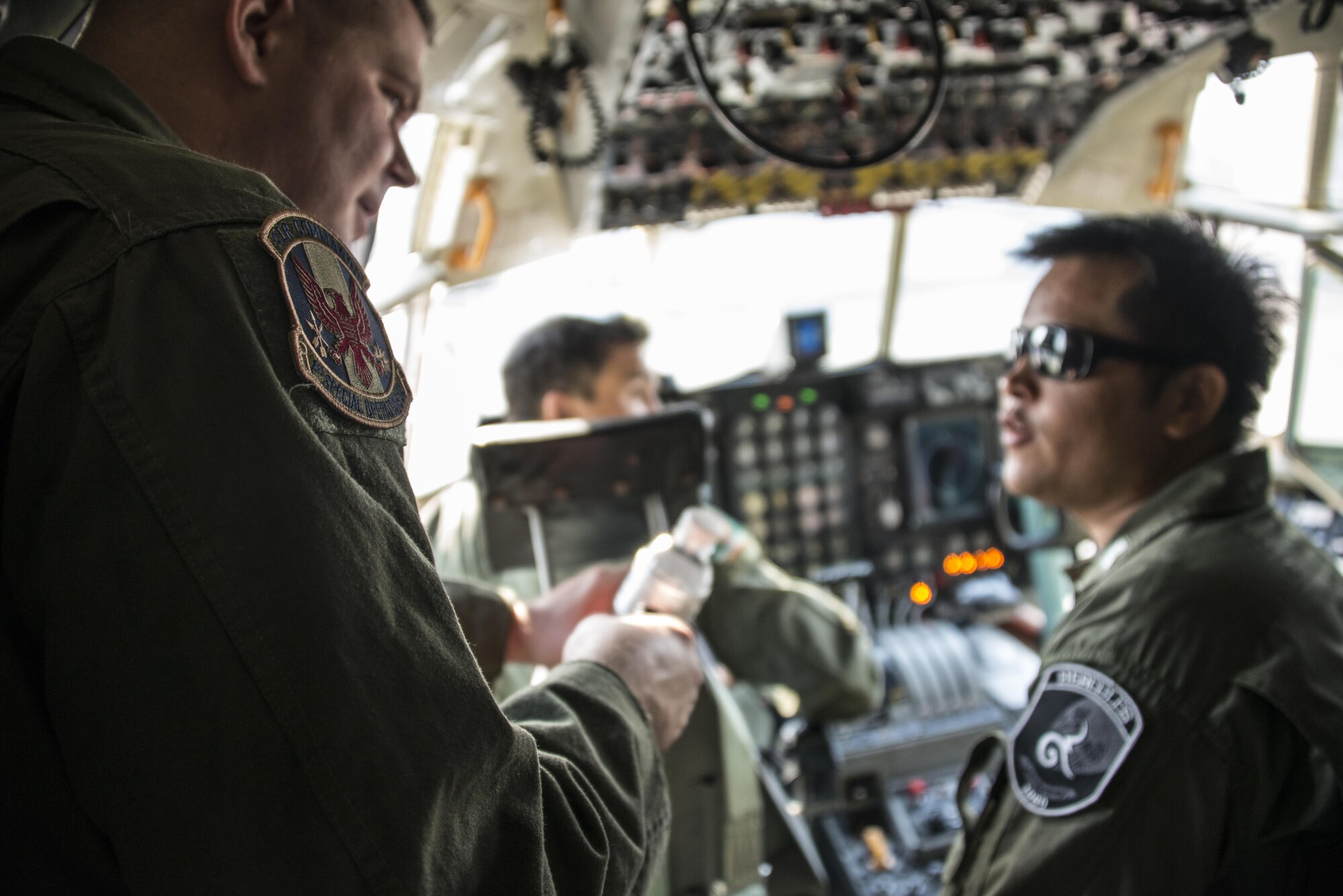U.S. Air Force Master Sgt. Mark Callahan, 1st Special Operations Squadron evaluator flight engineer, engages with his counterpart during an observation flight, March 3, 2017 at Don Mueang Air Base, Thailand. Teak Torch 2017 enabled the 353rs Special Operations Group the opportunity to exchange knowledge and procedures with the Royal Thai Air Force 601st Squadron in order to advance interoperability and increase partner capacity. (U.S. Air Force photo by Capt. Jessica Tait)