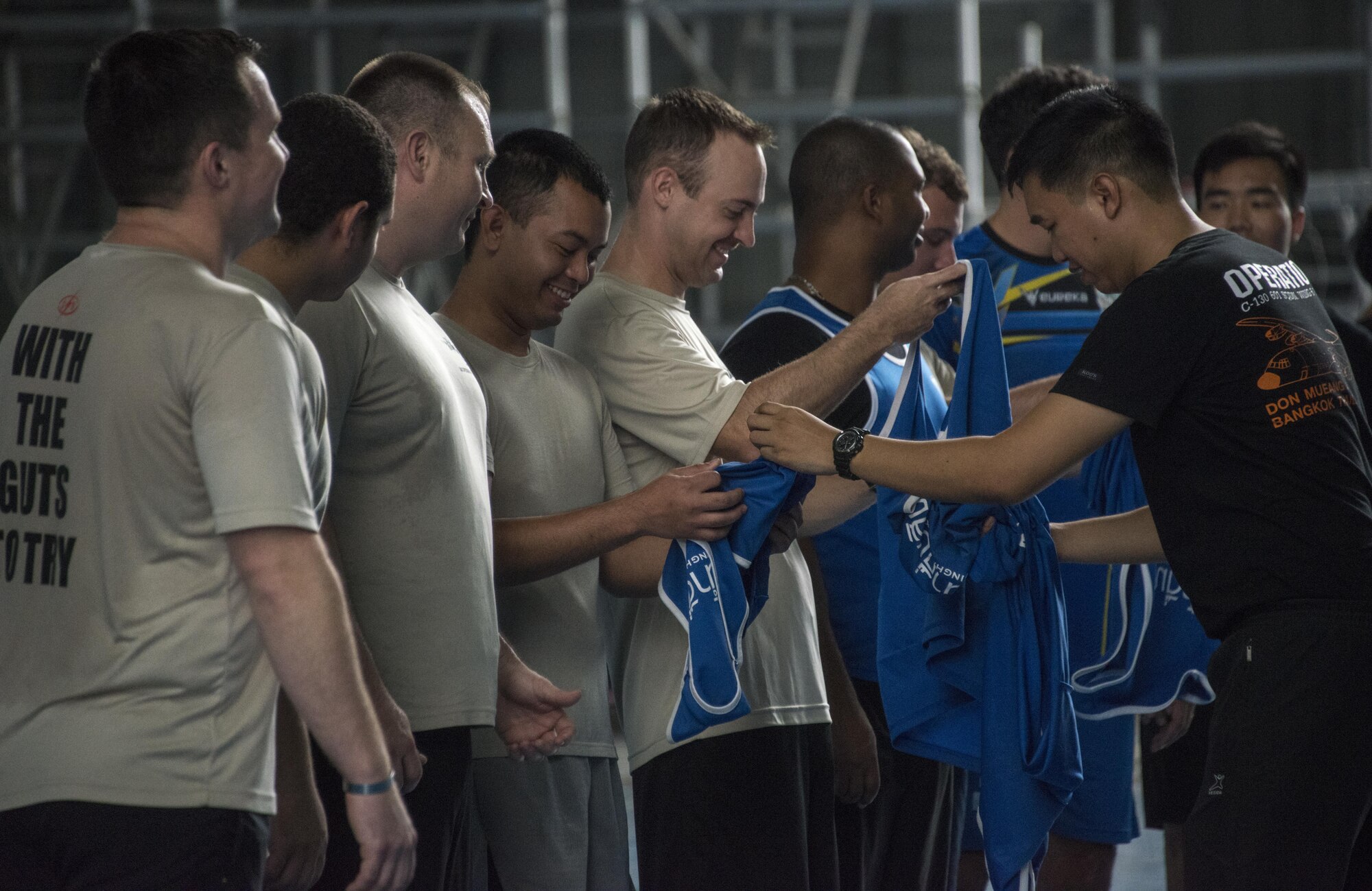 Members of the Royal Thai Air Force 601st Squadron distribute jerseys to U.S. Air Force members from the 353rd Special Operations Group during a sports day event, March 8, 2017 at Don Mueang Air Base, Thailand. Teak Torch 2017 provided an opportunity for both the United States and Thailand to advance interoperability and increase partner capacity. (U.S. Air Force photo by Capt. Jessica Tait)