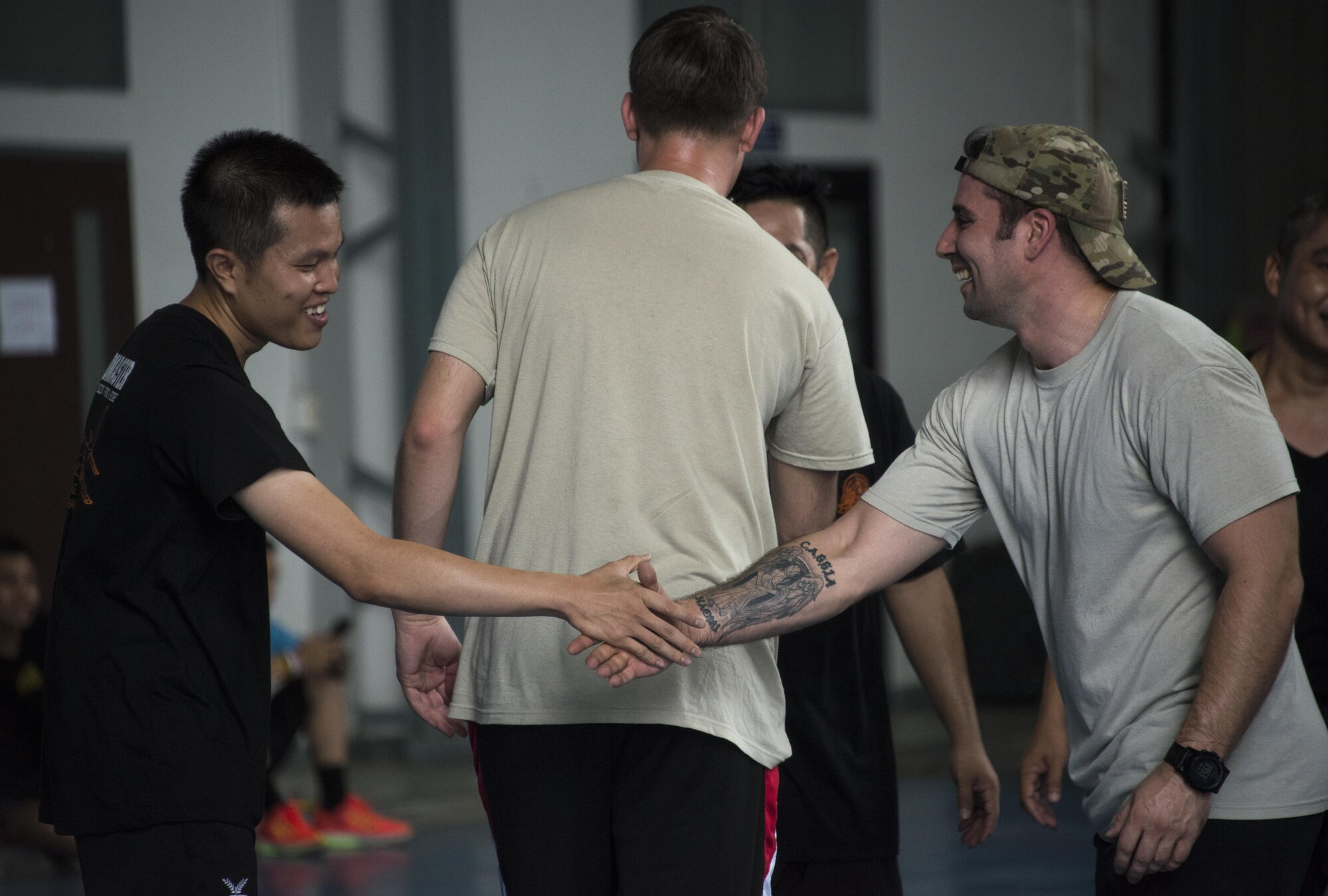 U.S. Air Force Tech. Sgt. Fattorusso, 1st Special Operations Squadron evaluator loadmaster, shakes hands with a member of the Royal Thai Air Force 601st Squadron following a basketball game, March 8, 2017 at Don Mueang Air Base, Thailand. Teak Torch 2017 focused on relationship building through social events like sports day in order to gain credibility and trust. (U.S. Air Force photo by Capt. Jessica Tait)