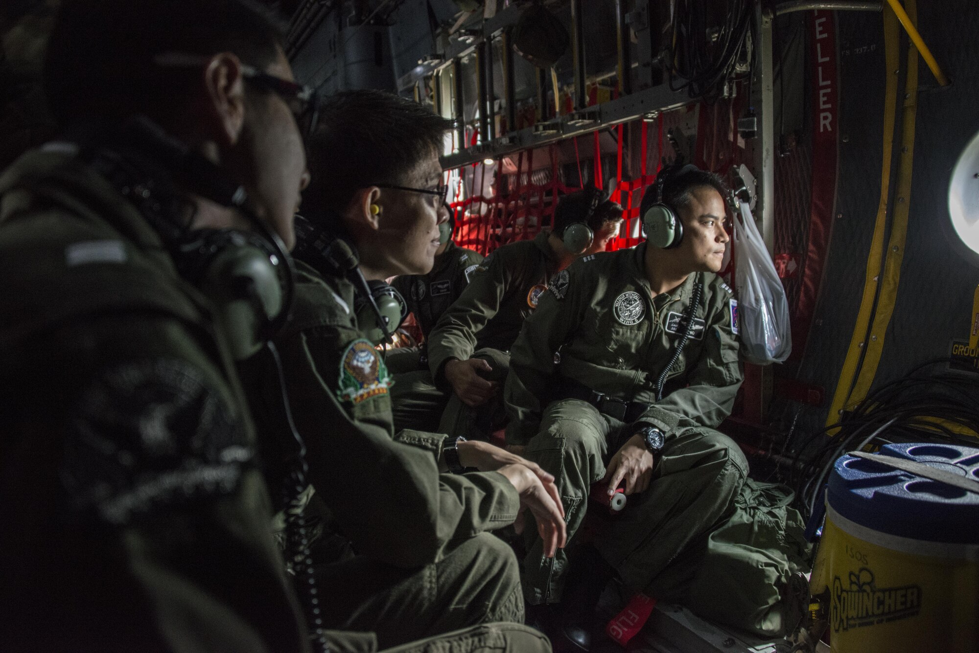 Royal Thai Air Force 601st Squadron aircrew look out the window of a U.S. Air Force MC-130H Talon II assigned to the 1st Special Operations Squadron during an observation flight, March 9, 2017 at Don Mueang Air Base, Thailand. The unit-to-unit exchanges conducted during Teak Torch 2017 support the training and educational requirements of the RTAF units. (U.S. Air Force photo by Capt. Jessica Tait)