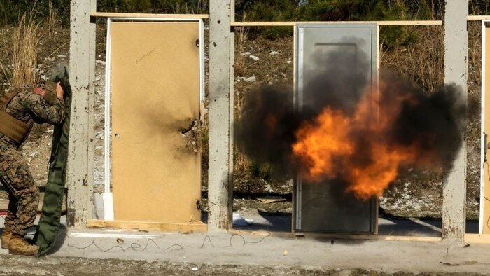 Marines detonate an explosive charge on a door during a breaching exercise at Marine Corps Base Camp Lejeune, N.C., March 30, 2017. The Marines and Sailors practiced techniques on how to successfully get through locked doors using shotguns and explosive charges. The Marines and sailors are with 2nd Reconnaissance Battalion. 
