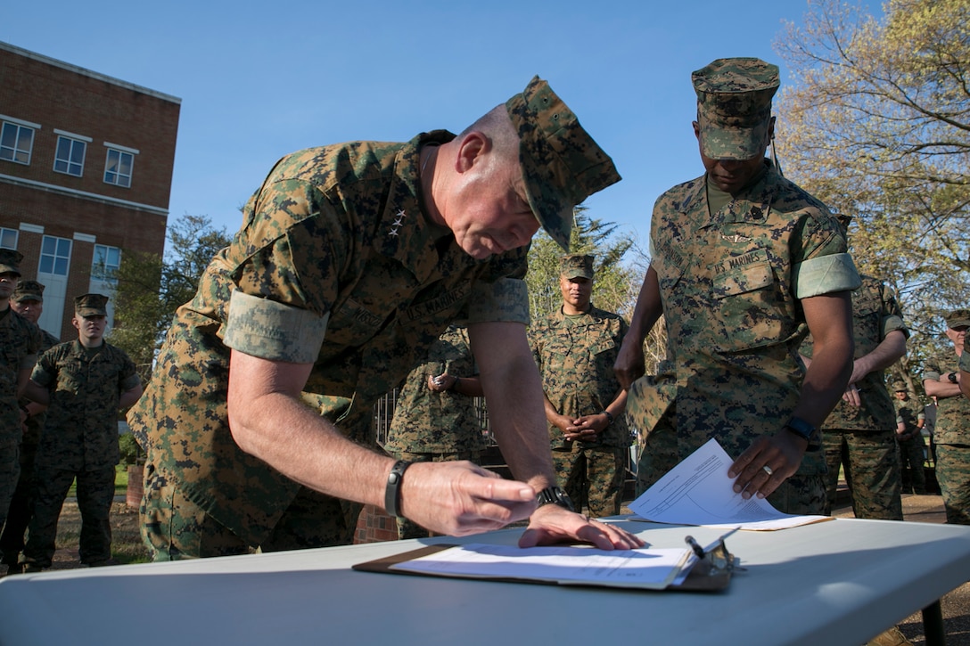 Lt. Gen. John E. Wissler, Commander, and Sgt. Maj. Christopher Robinson, sergeant major, U.S. Marine Corps Forces Command, take a moment to sign an administrative Page 11 document symbolizing the unified effort from the top down to support Commandant of the Marine Corps General Robert Neller’s efforts to combat  on-line misconduct, at NH33 aboard Naval Support Activity Hampton Roads on April 3, 2017. Before signing his Page 11, Lt. Gen. Wissler addressed the headquarters staff regarding this recent atrocity, making it clear that conduct unbecoming of a Marine, enlisted or officer, male or female, would not be tolerated, and that we as Marines must continue to not only respect one another, but honor the Marine to our left and right and maintain our ethos of Honor, Courage, and Commitment to God, Country, and Corps. (Official Marine Corps photo by Sgt. Calvin Shamoon/Released)